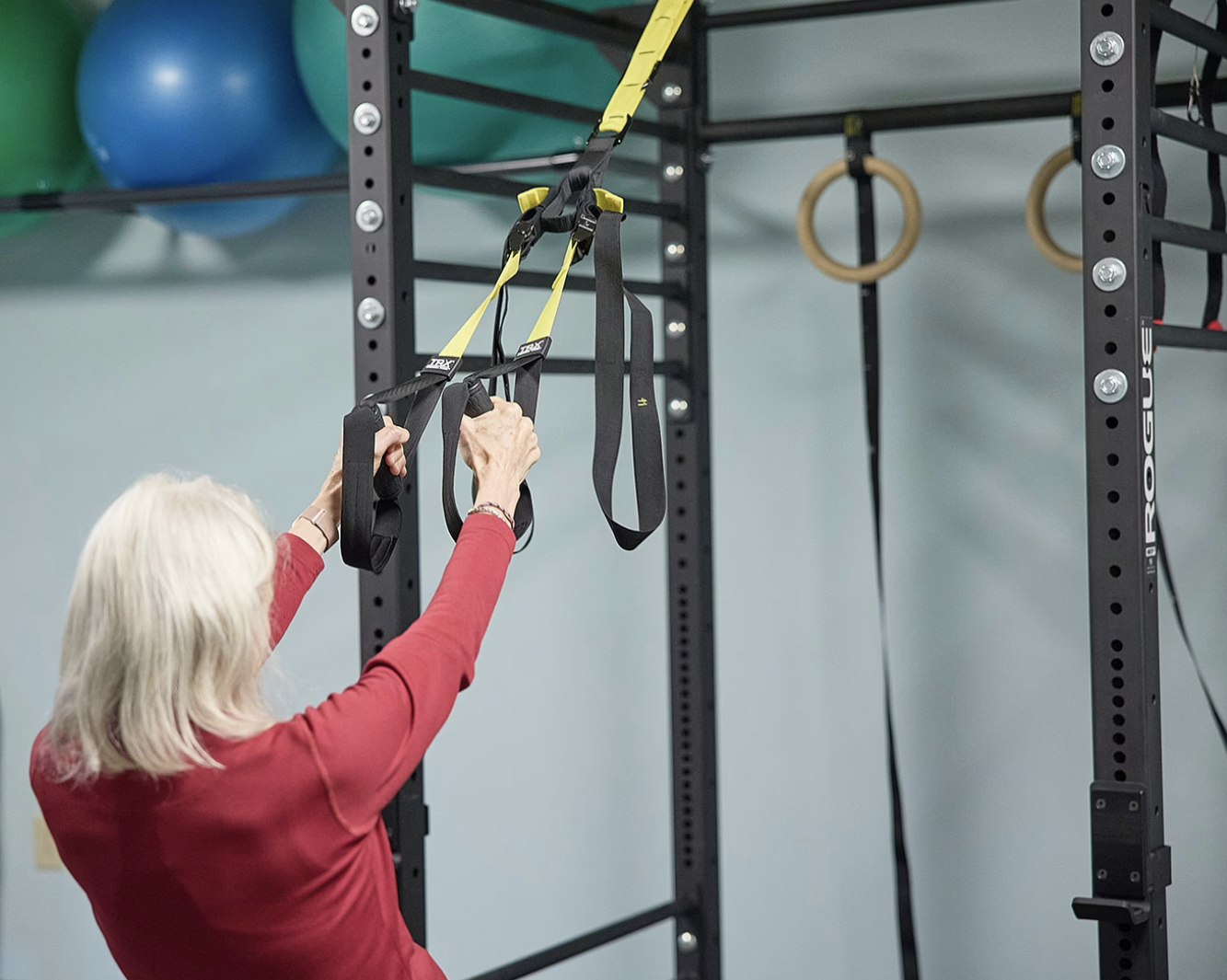Woman in red performing TRX training at Advance FIT